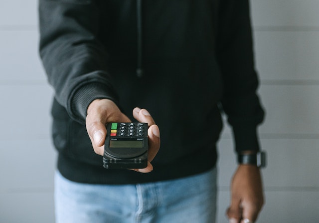 man holding portable card machine 